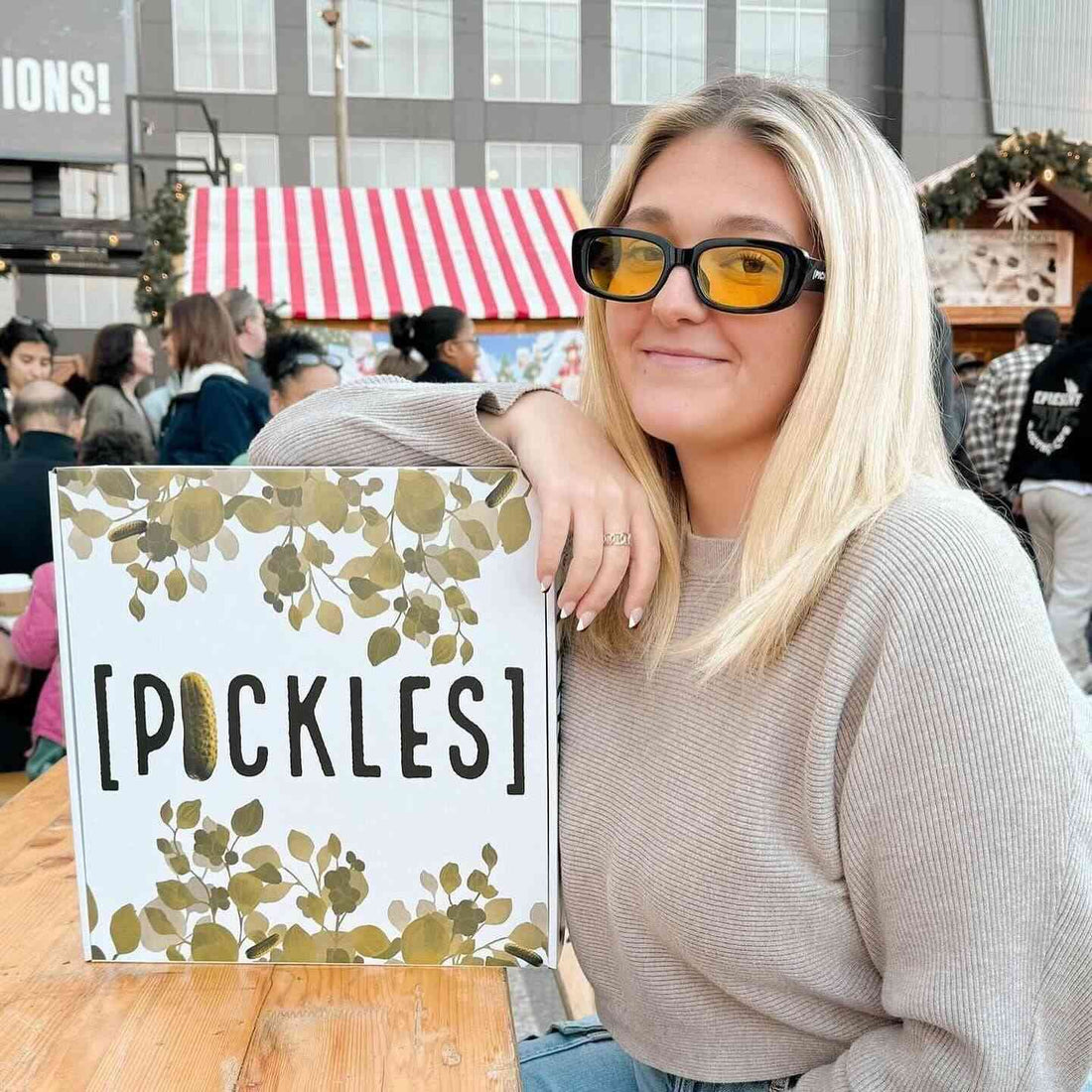 Woman wearing yellow-tinted Pickle Sunglasses with UV protection, black frame, and yellow lenses, outdoor event, SKU: 761885307003-BLK