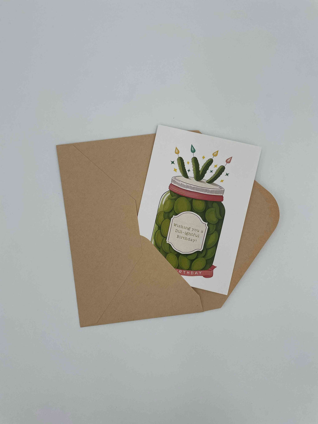 Birthday card showing a jar of pickles with candles, on a kraft envelope