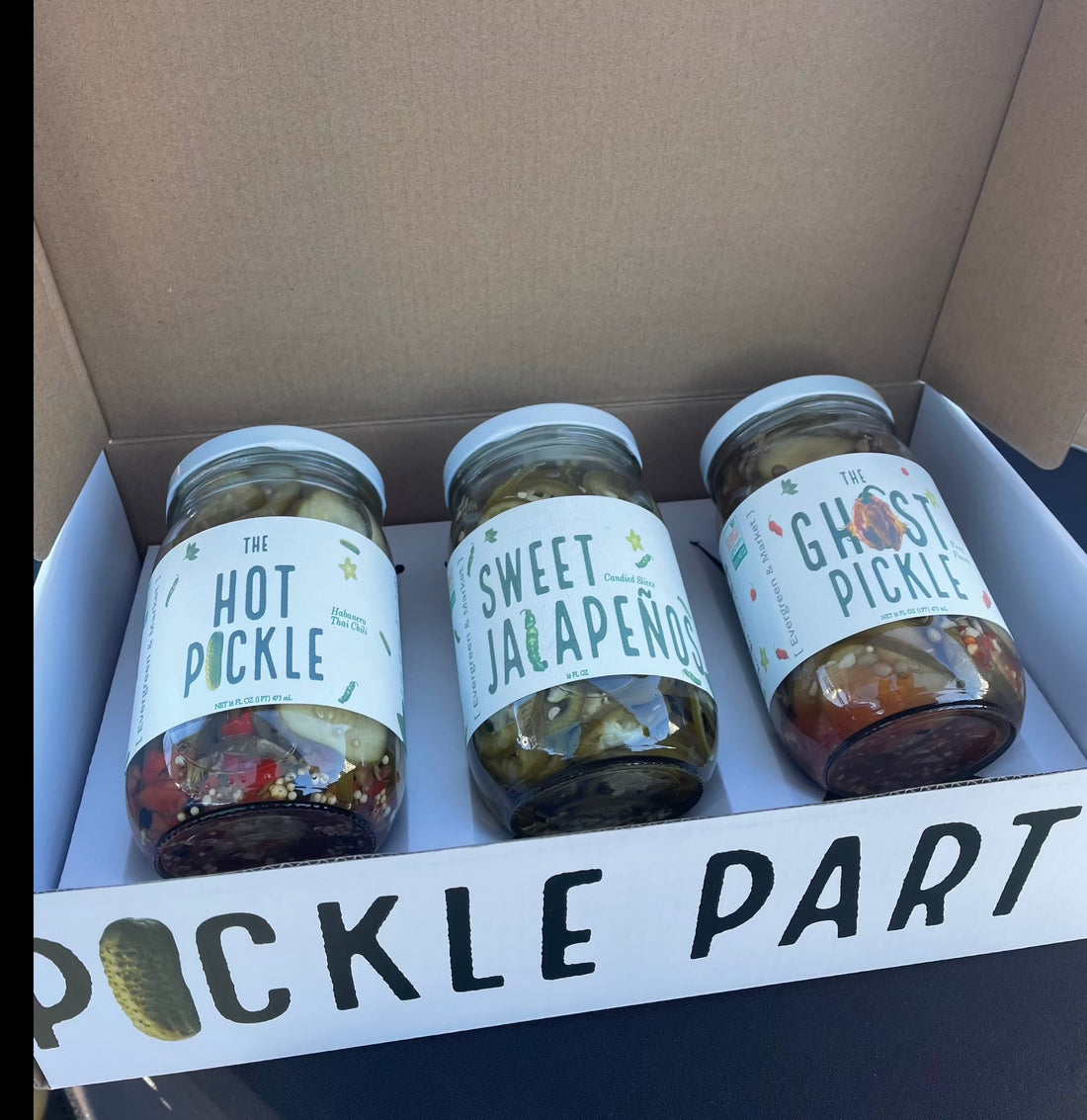 Pickle Party box holding three jars: The Hot Pickle, Sweet Jalapeño and The Ghost Pickle