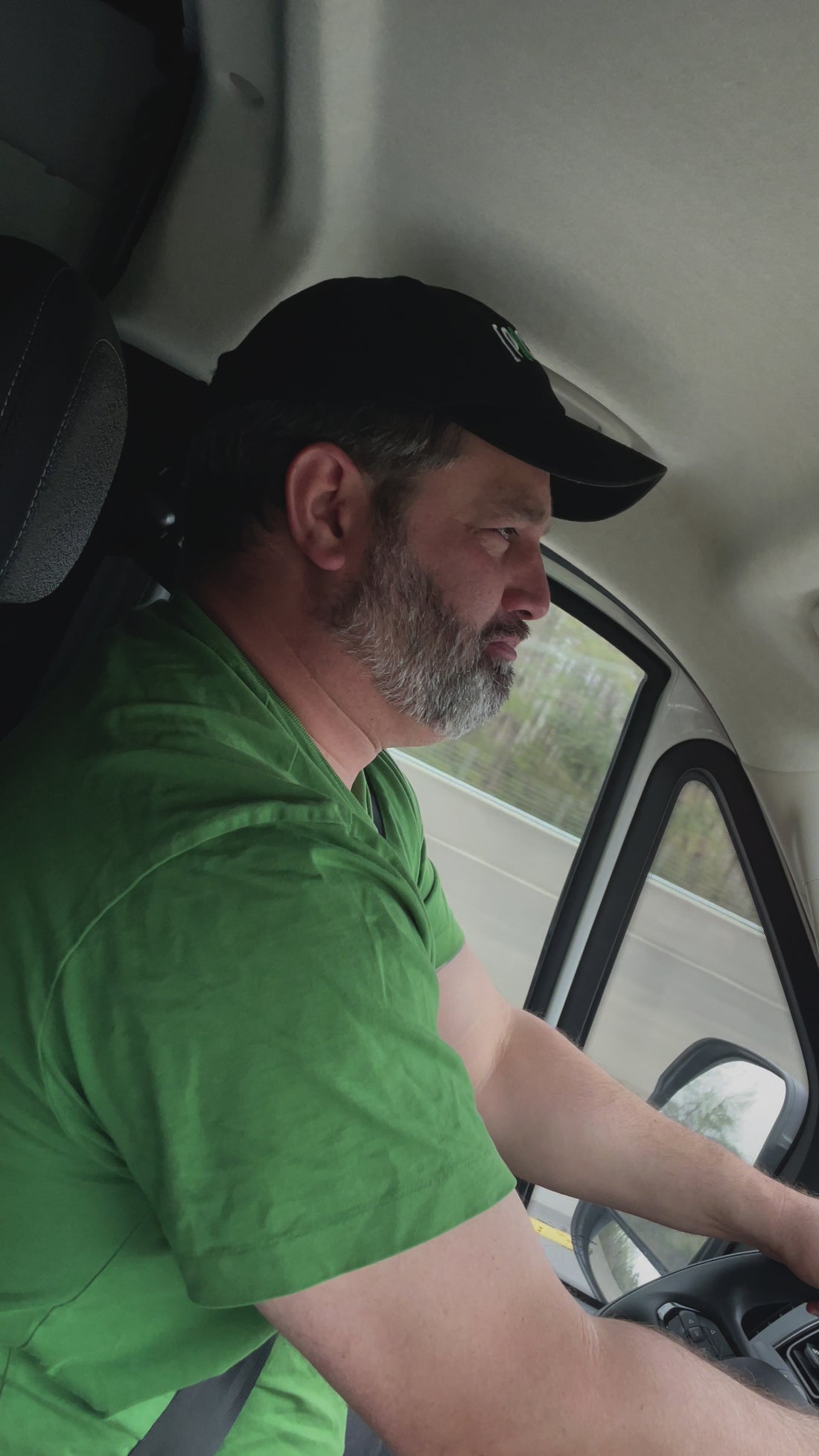 Video of a man wearing the black [PICKLES] cap while driving